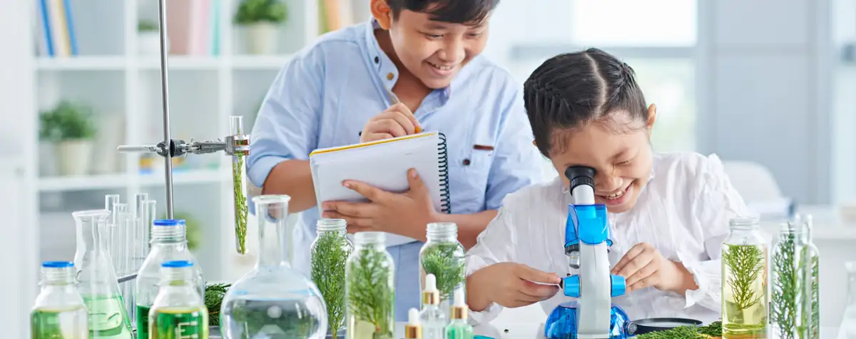 Dua anak melakukan eksperimen sains di laboratorium